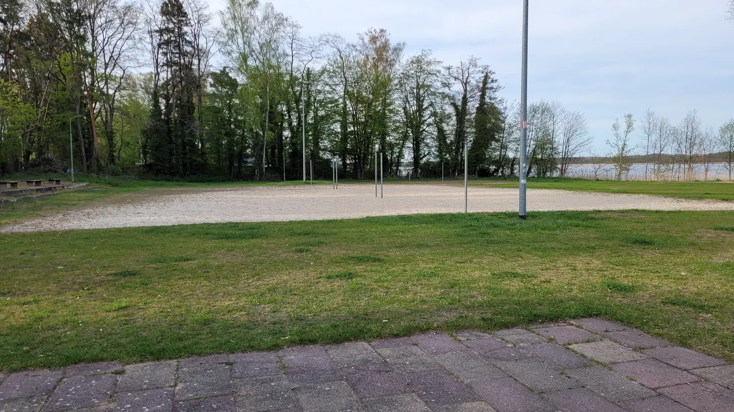 Beachvolleyballfeld in Klausdorf mit Sand, Rasen und Bäumen