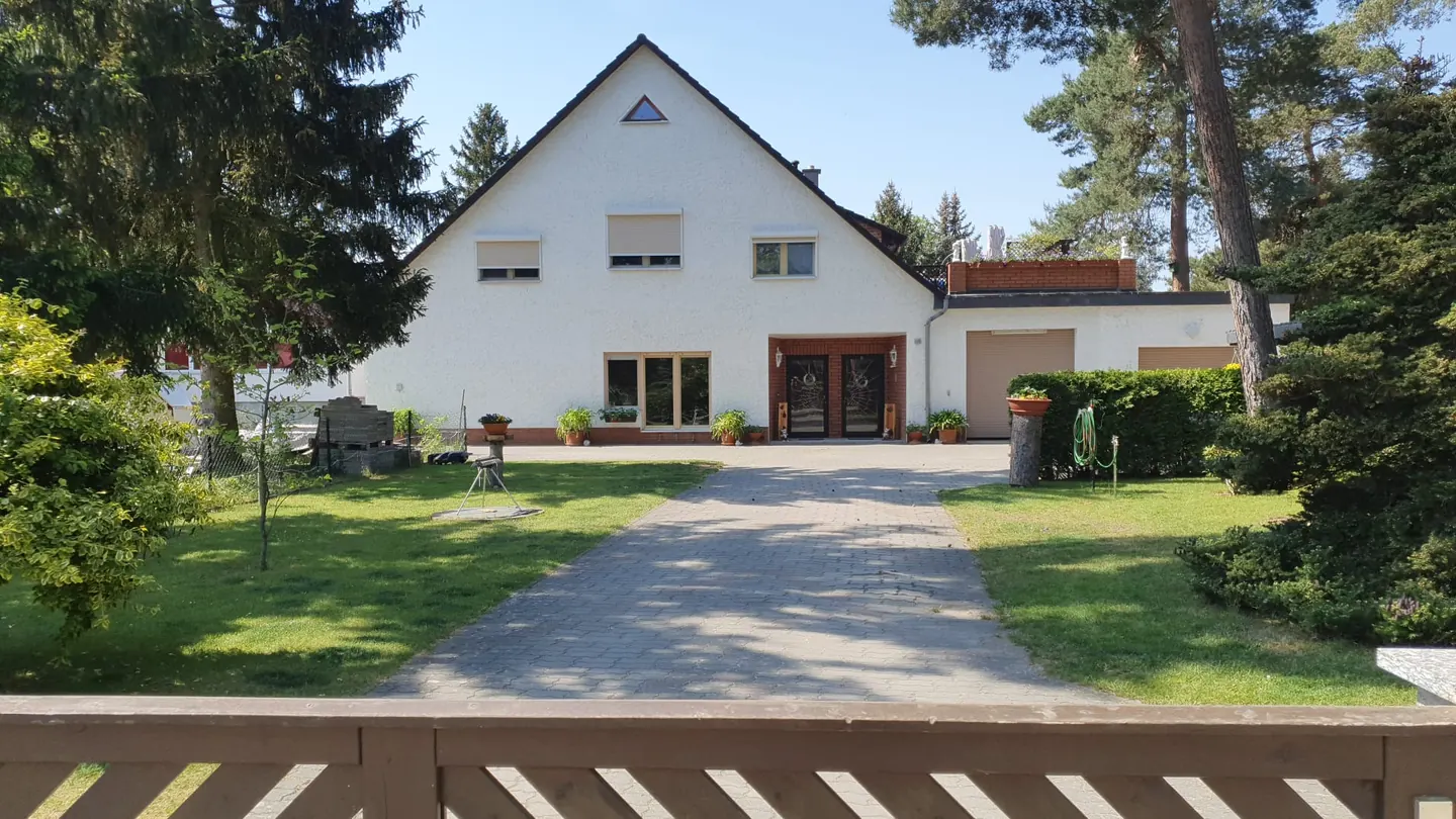 Das Haus der Anglerhütte-Jäkel mit Einfahrt und Rasen an einem sonnigen Tag