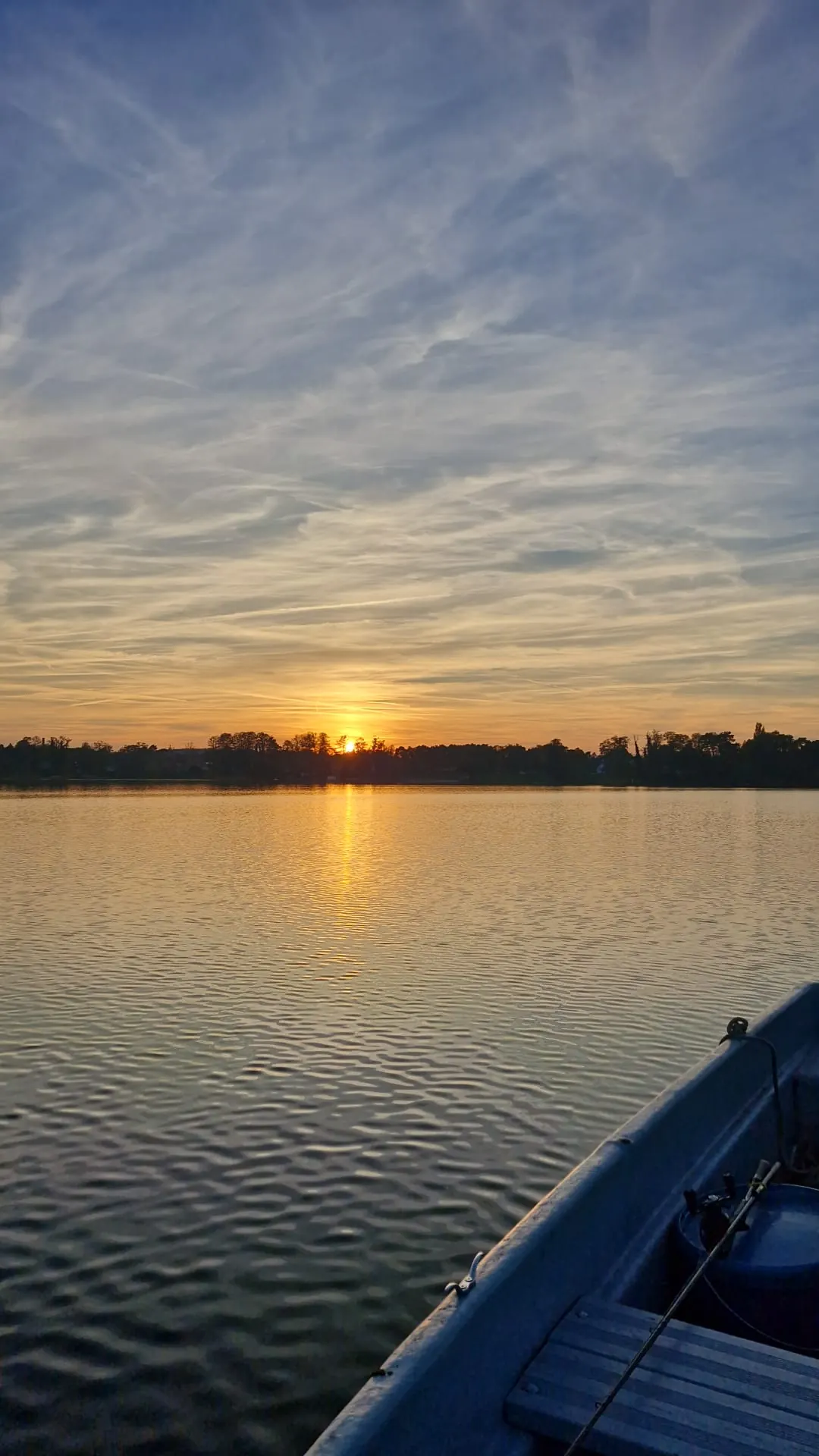 Sonnenuntergang über dem Mellensee, vom Ruderboot aus gesehen — die Sonne spiegelt sich im Wasser