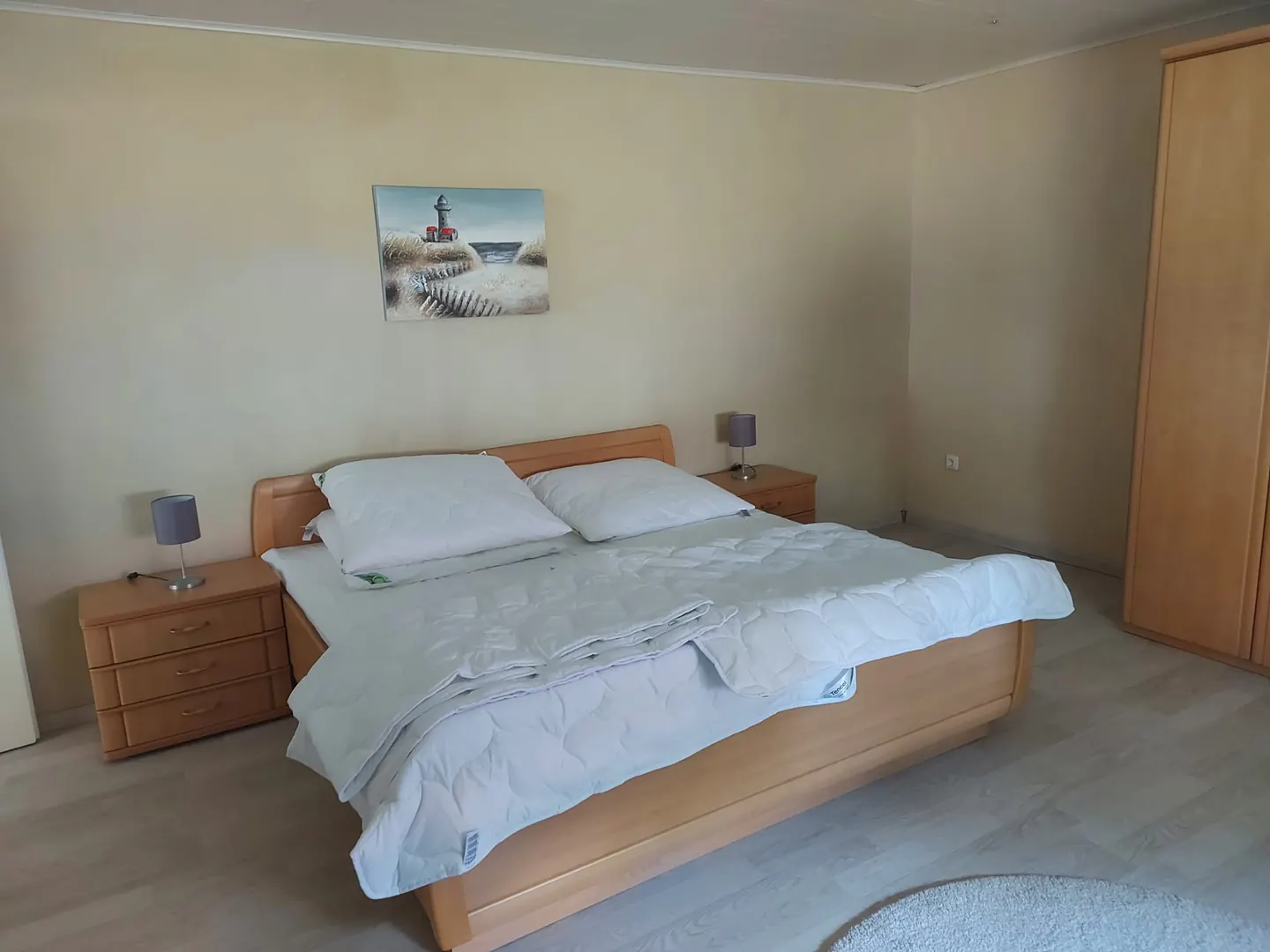 Schlafzimmer mit Doppelbett aus Holz, Nachttischen und großem Kleiderschrank